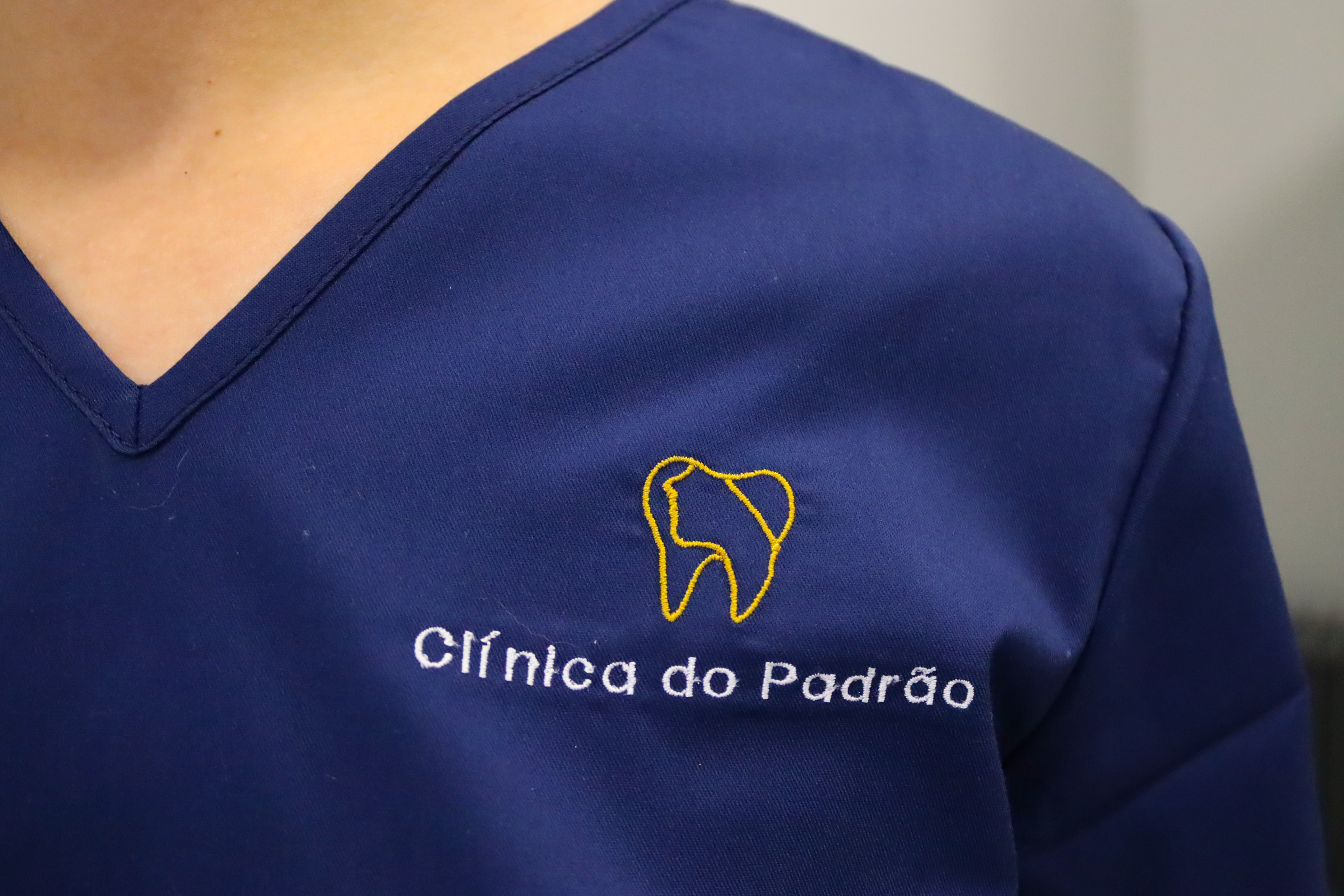 Detalhe do logótipo da clínica no uniforme